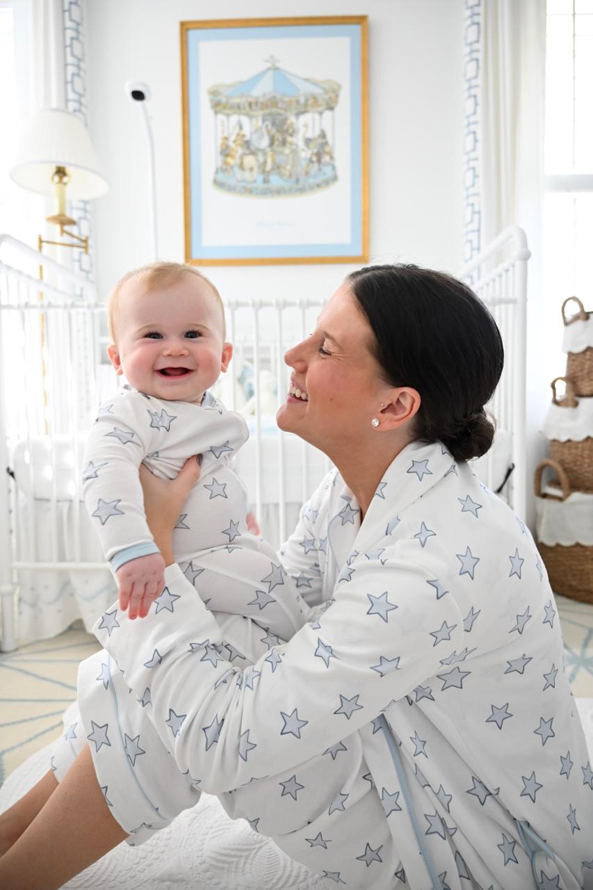Mother and baby in matching star print pajamas outdoors